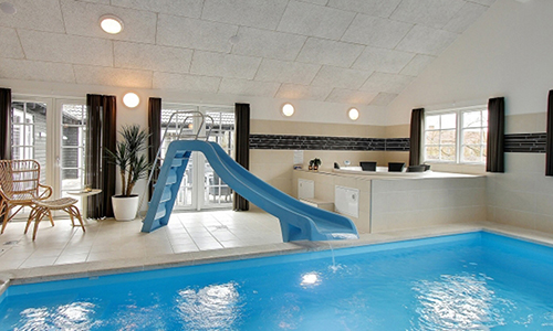 Blick auf einen Swimmingpool mit Wasserrutsche und einen Whirlpool im Poolbereich