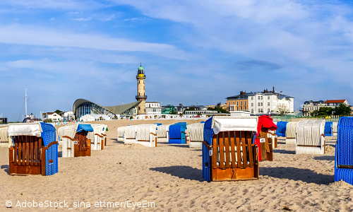 Blick vom Strand mit Strandkörben in Warnemünde zum Bauwerk "Teepott" und dem Leuchtturm